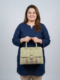 A woman wearing a navy blue tunic holds a light olive green textured handbag with a brown and beige gingham patterned accent strip on the front. The brand name 'Savvy' is visible on the bag against a solid light gray background.