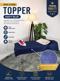 An iron stand with a navy blue fabric toppper, shown in a styled room setting with a lamp, plant, and folded clothing. The image includes feature callouts and a circular inset showing the navy blue fabric texture.